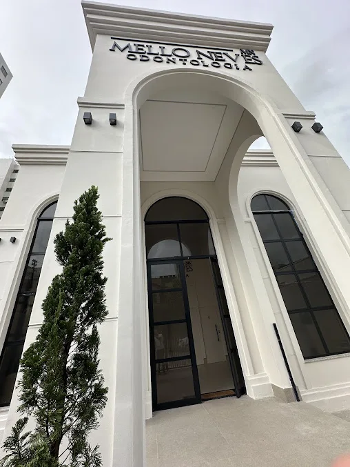 Fachada de entrada com portão em arco e paisagismo